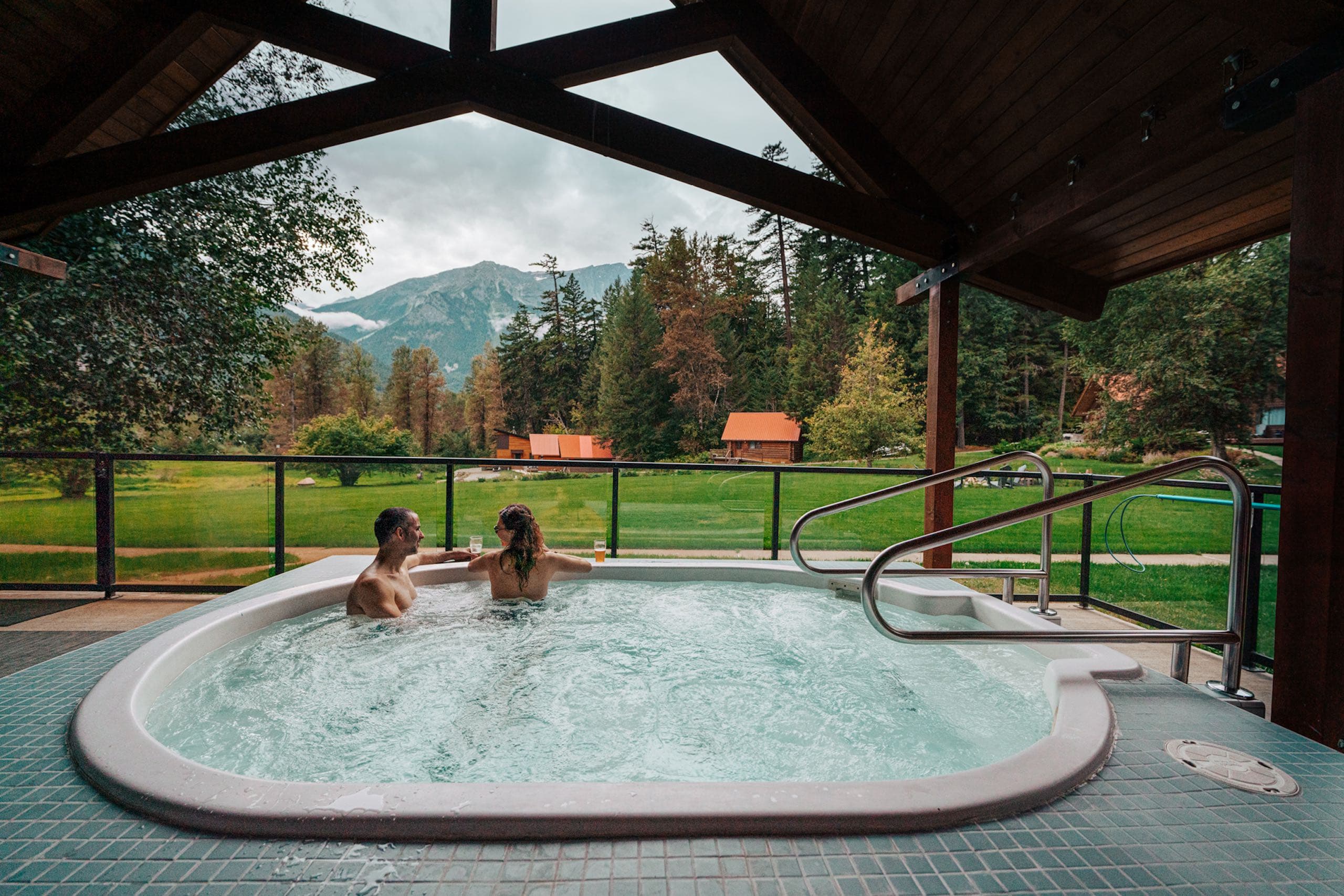 A couple in a hot tub looking out over the lawn