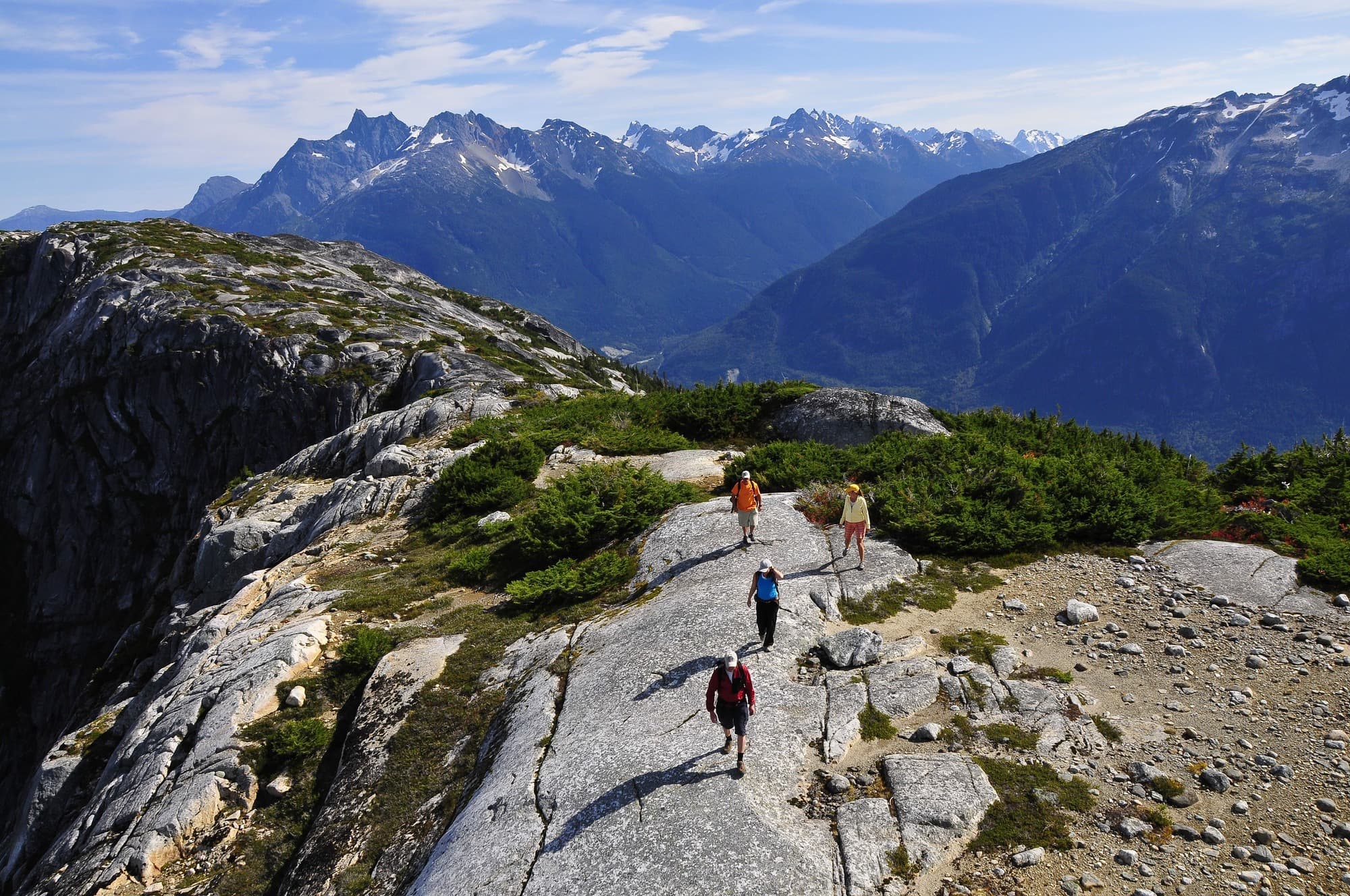 a group walking along a path in the mountains