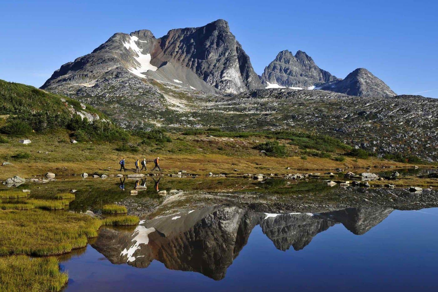 A group of people walking by glacial waters