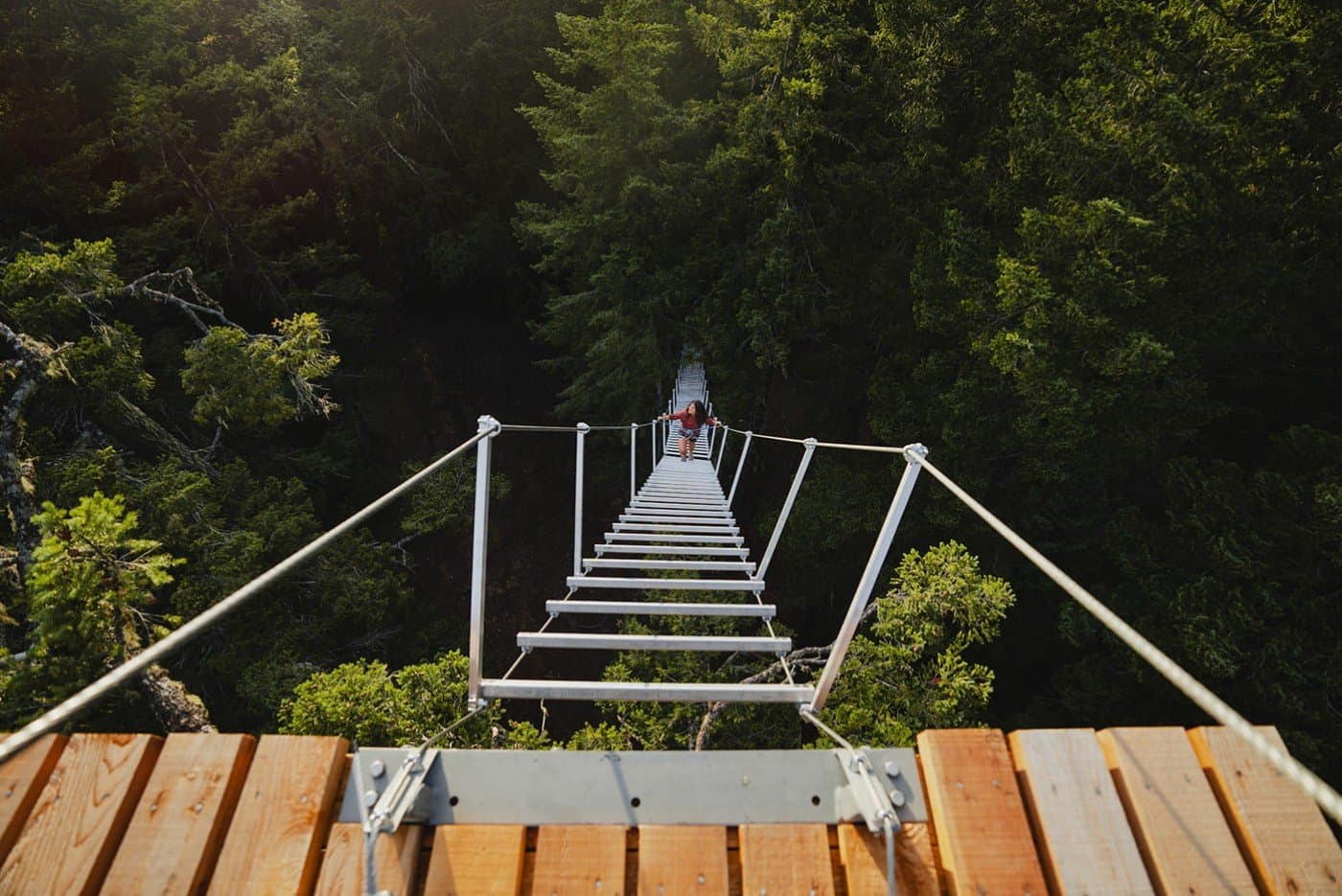 A woman climbing up a rope stair case